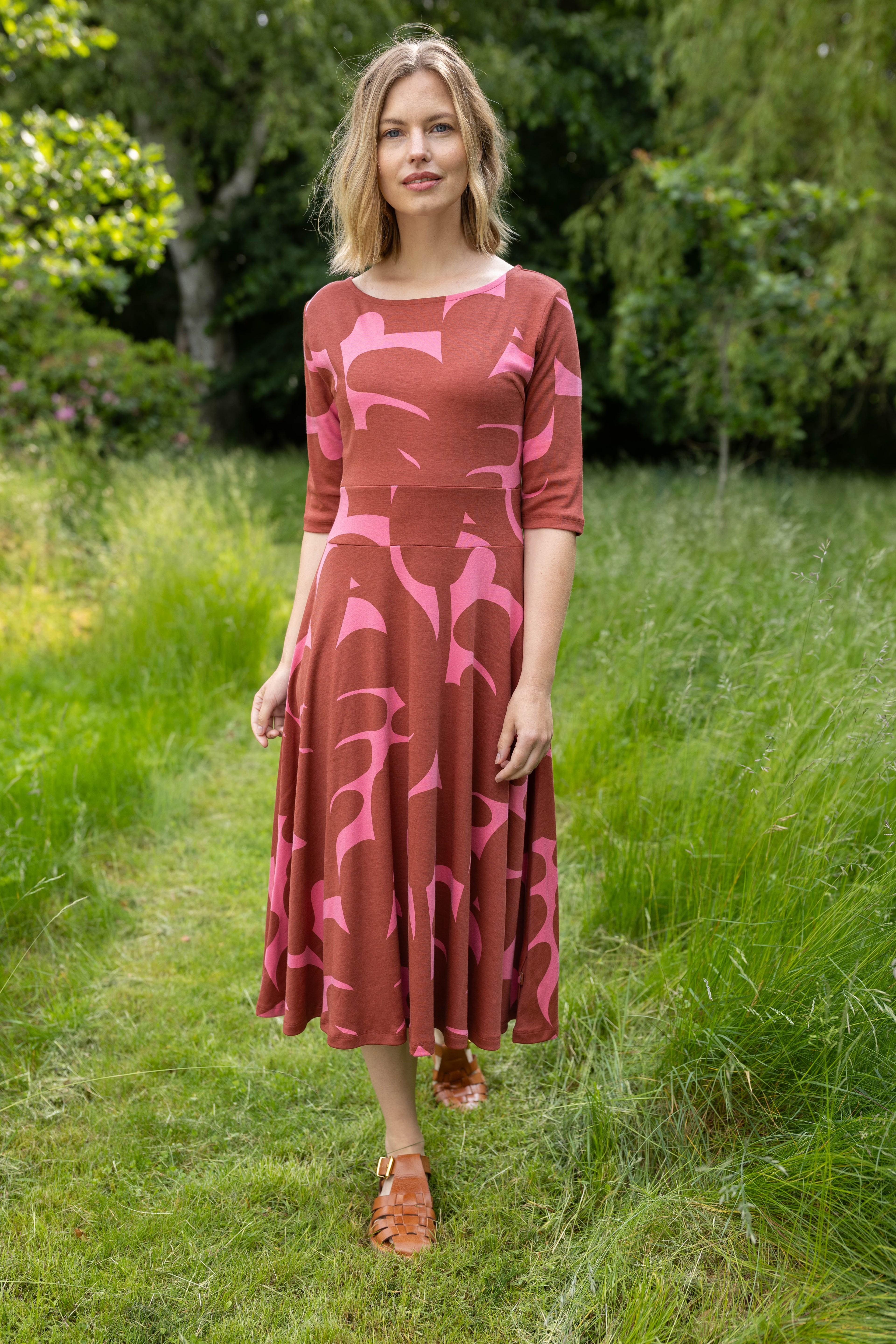 Sød kjole med abstrakt mønster i brændt rød og pink til kvinder