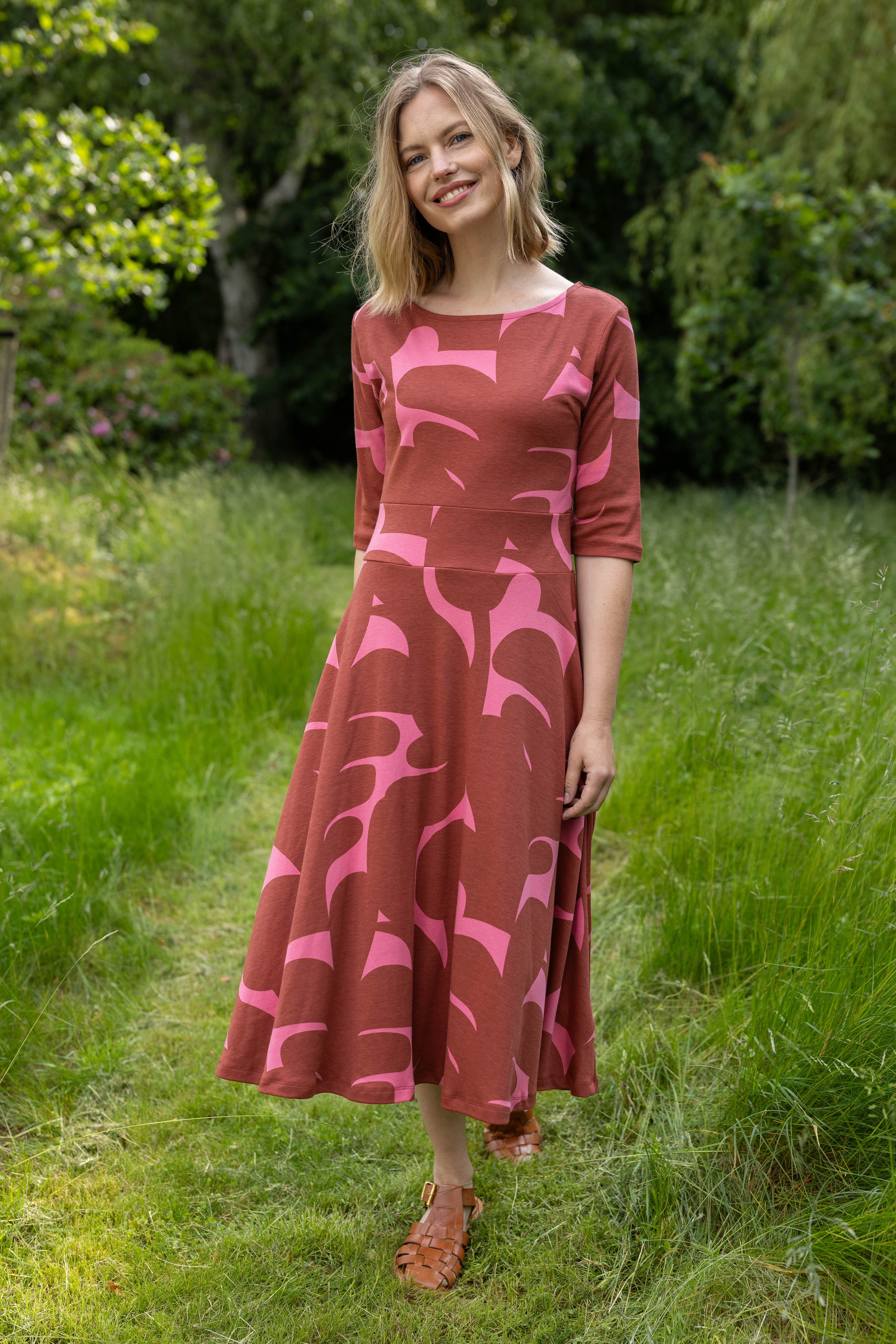 Sød kjole med abstrakt mønster i brændt rød og pink til kvinder