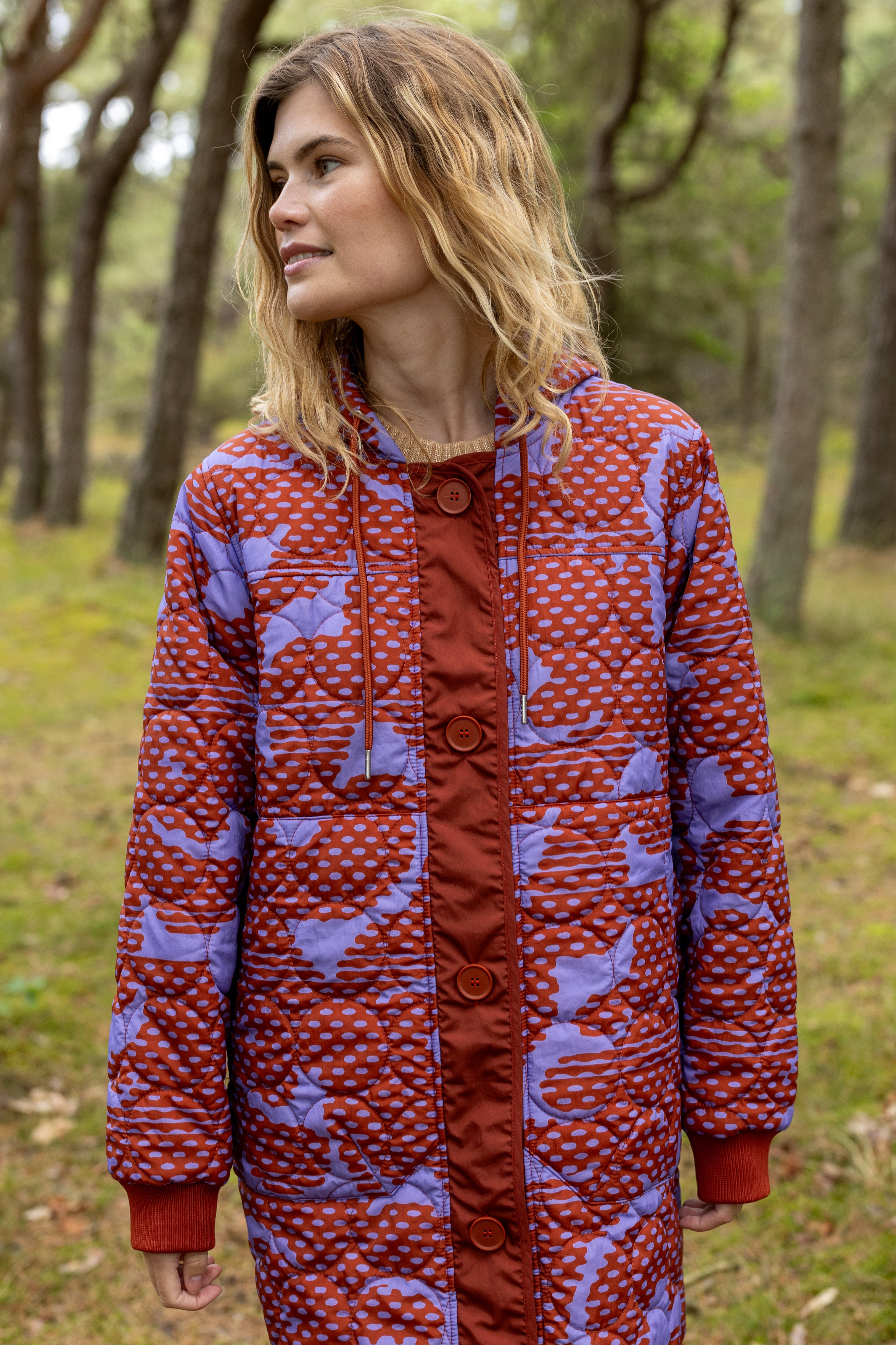 Lang quiltet termojakke med mønster i brændt rød og lyslilla til kvinder