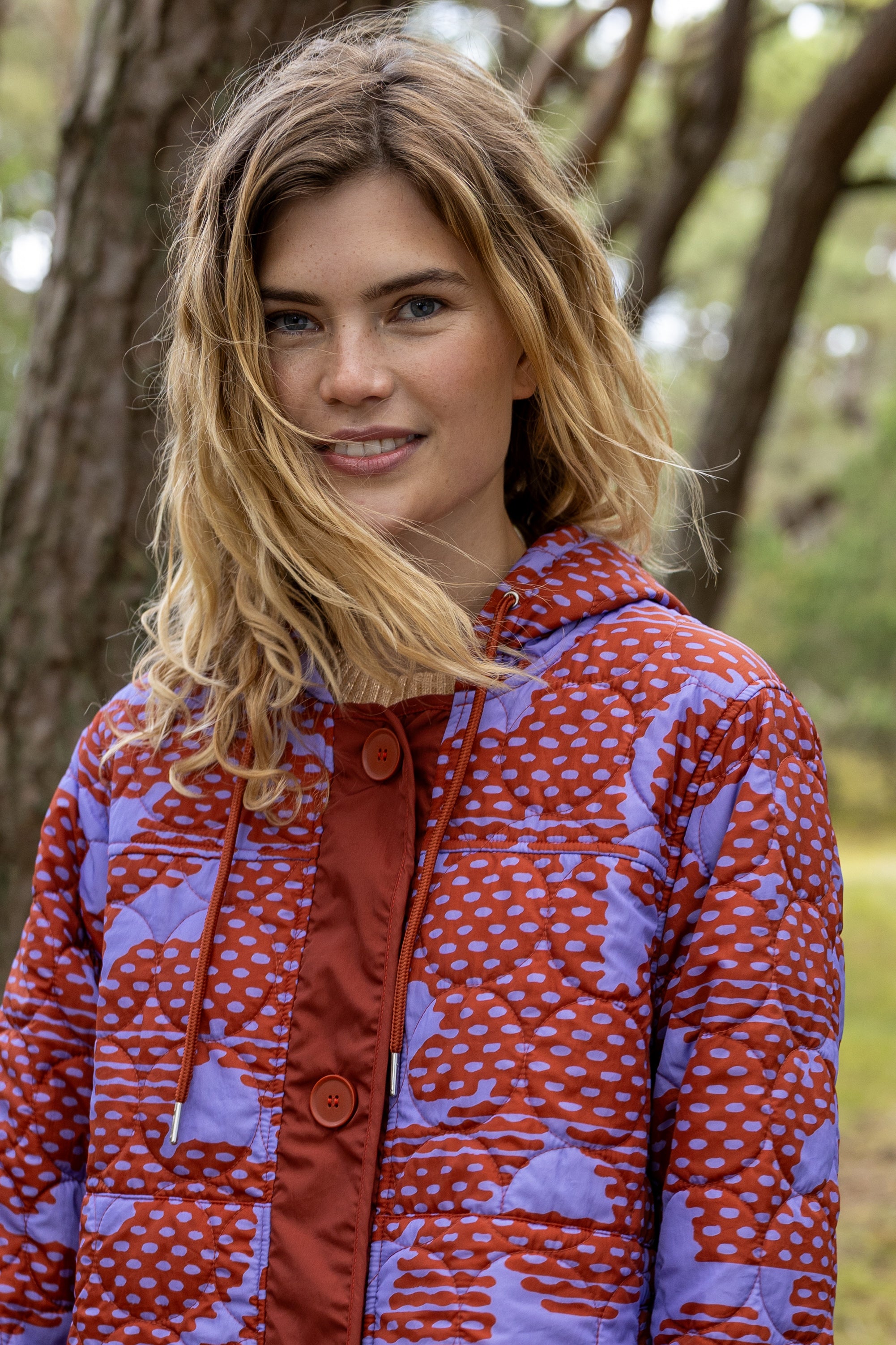 Lang quiltet termojakke med mønster i brændt rød og lyslilla til kvinder