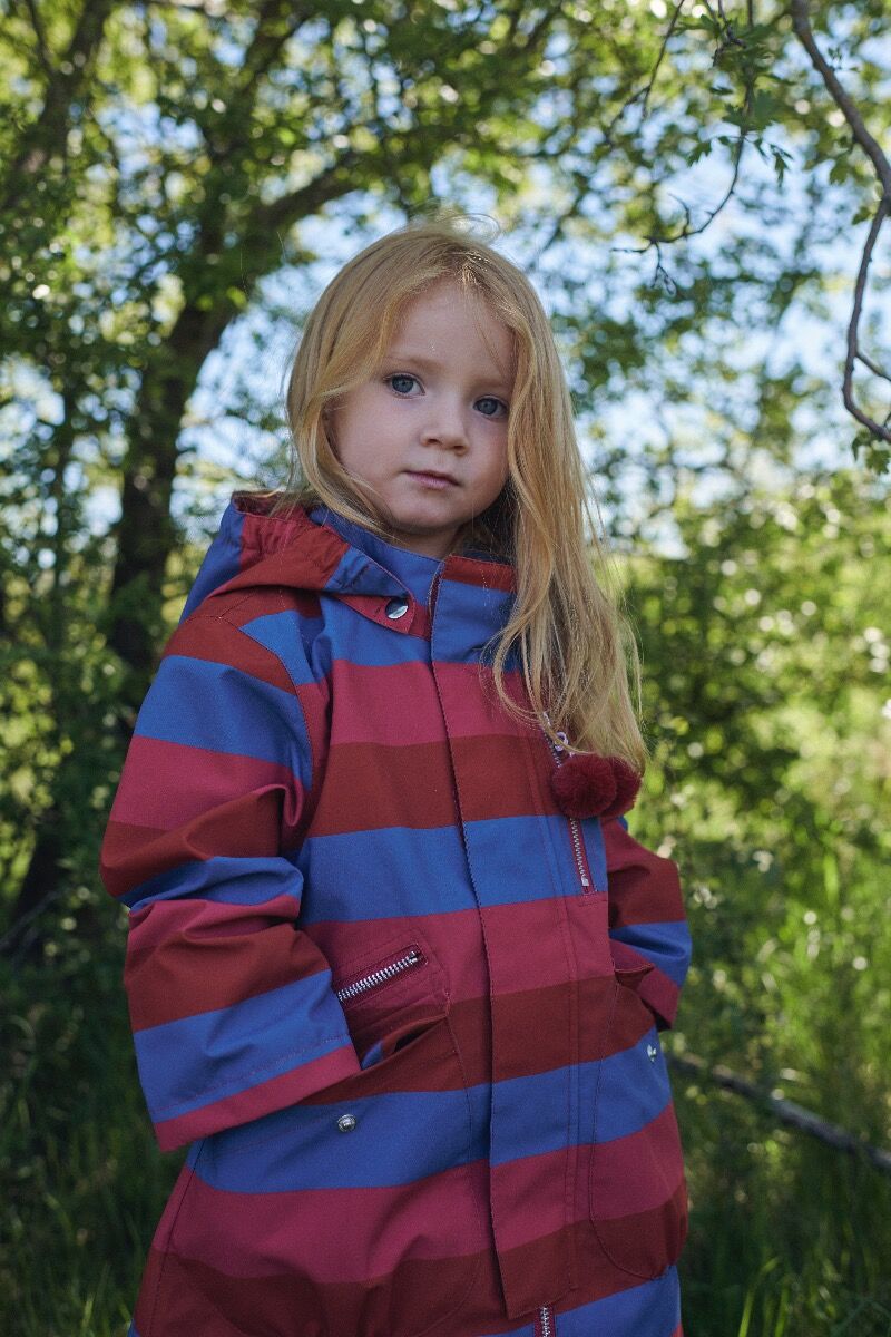 Lille pige med en stribet regnfrakke på