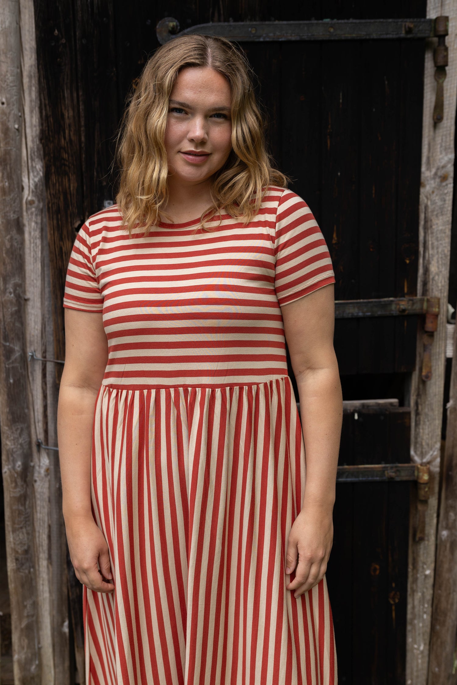 Sød kjole med striber i brændt rød og sandfarve til kvinder