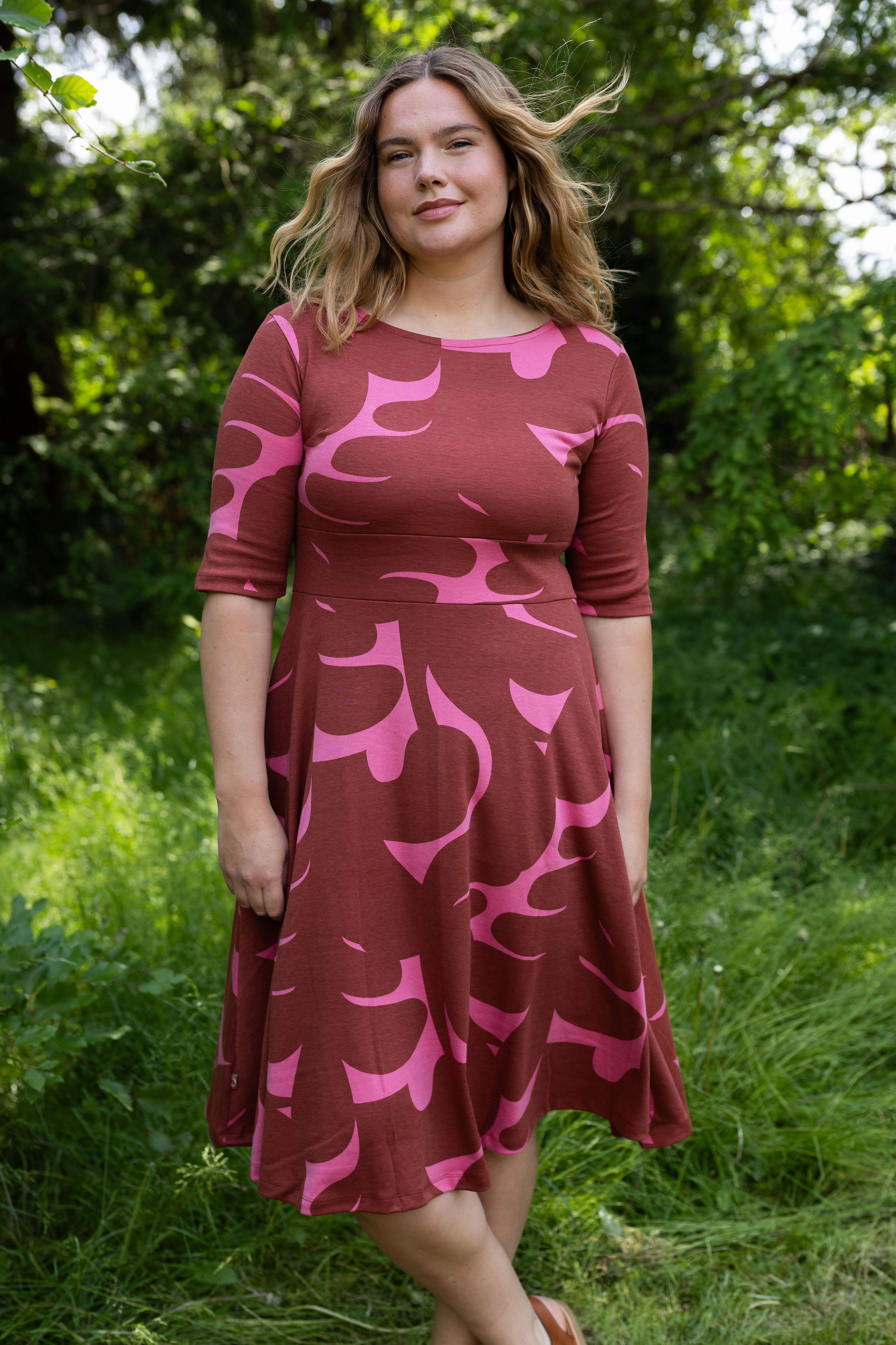 Sød kjole med abstrakt mønster i brændt rød og pink til kvinder