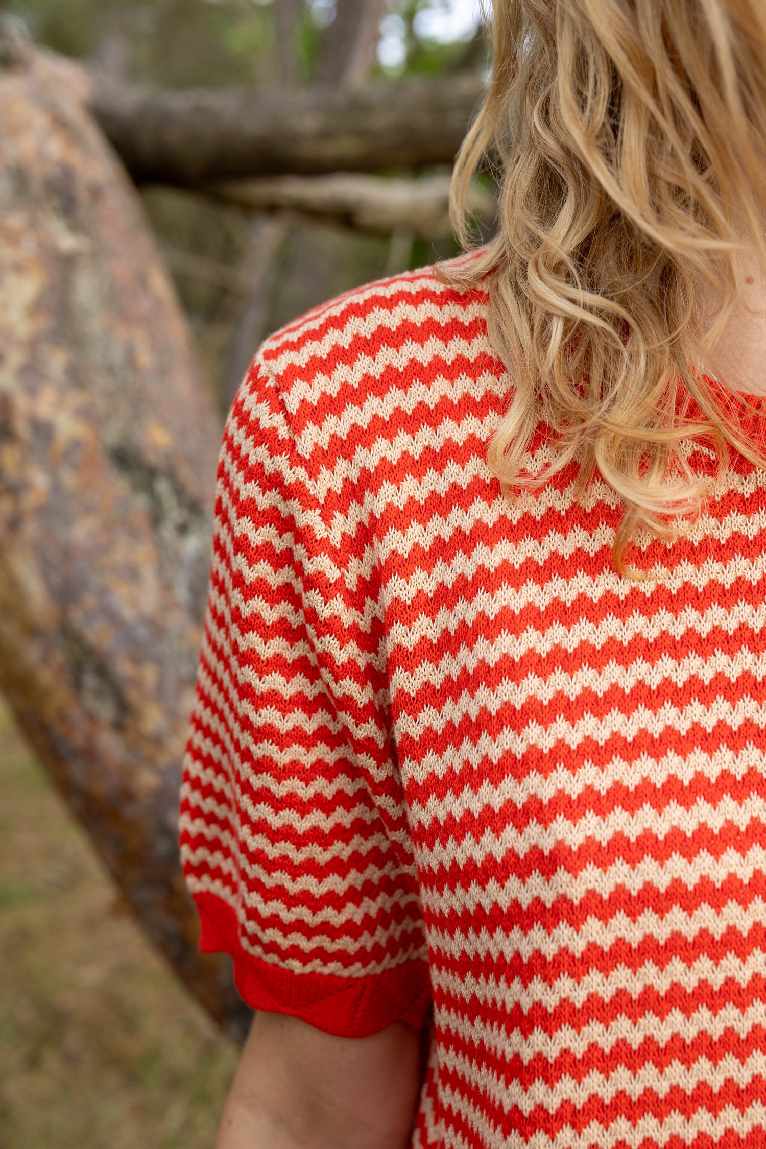 Sød kortærmet kjole i perlestrik med bølgede striber i rød og varm sandfarve