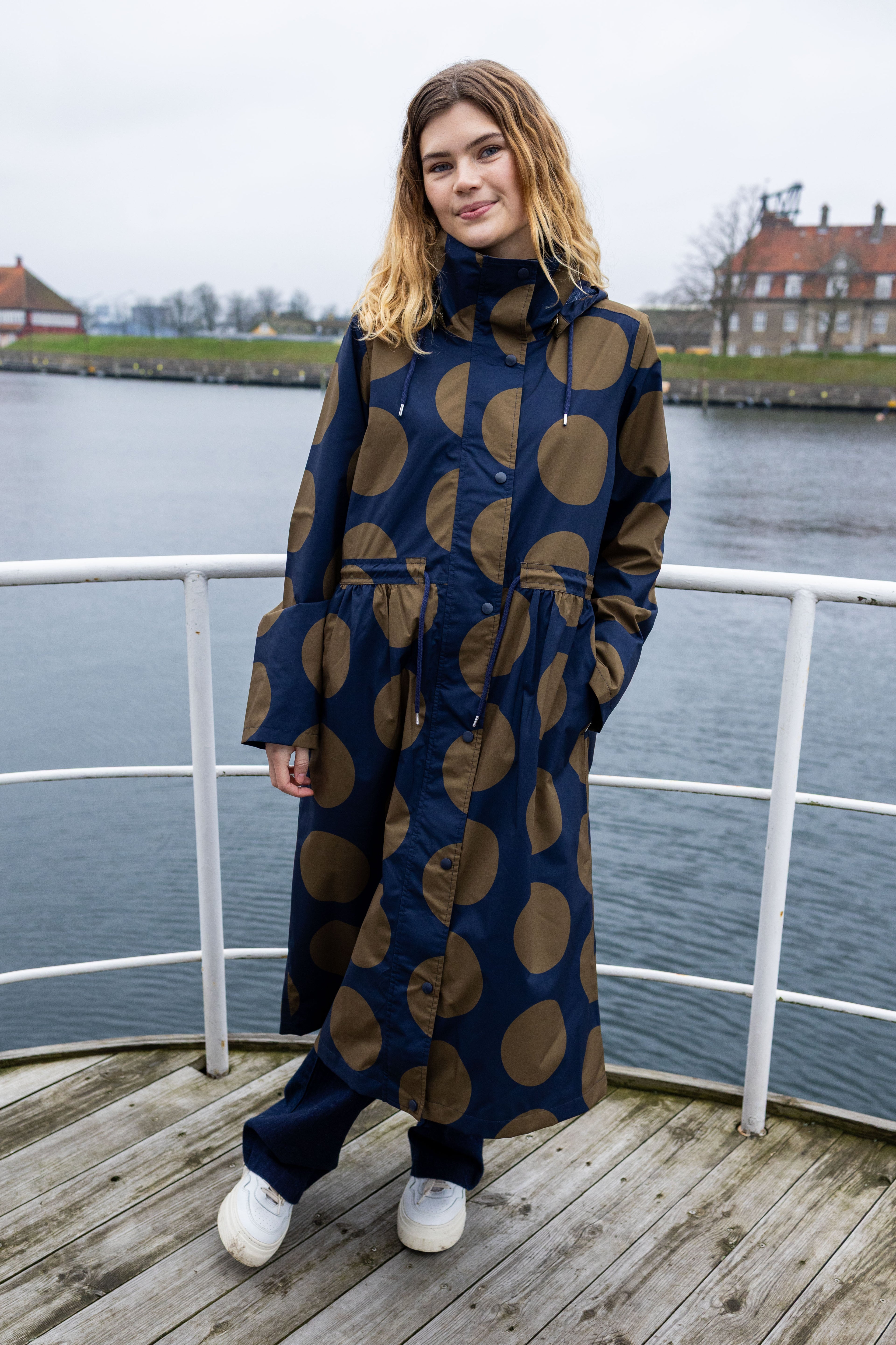 Stilfuld og praktisk regnfrakke i navyblå med olivengrønne prikker til kvinder