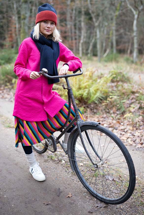 Kvinde på cykel med pink termojakke 